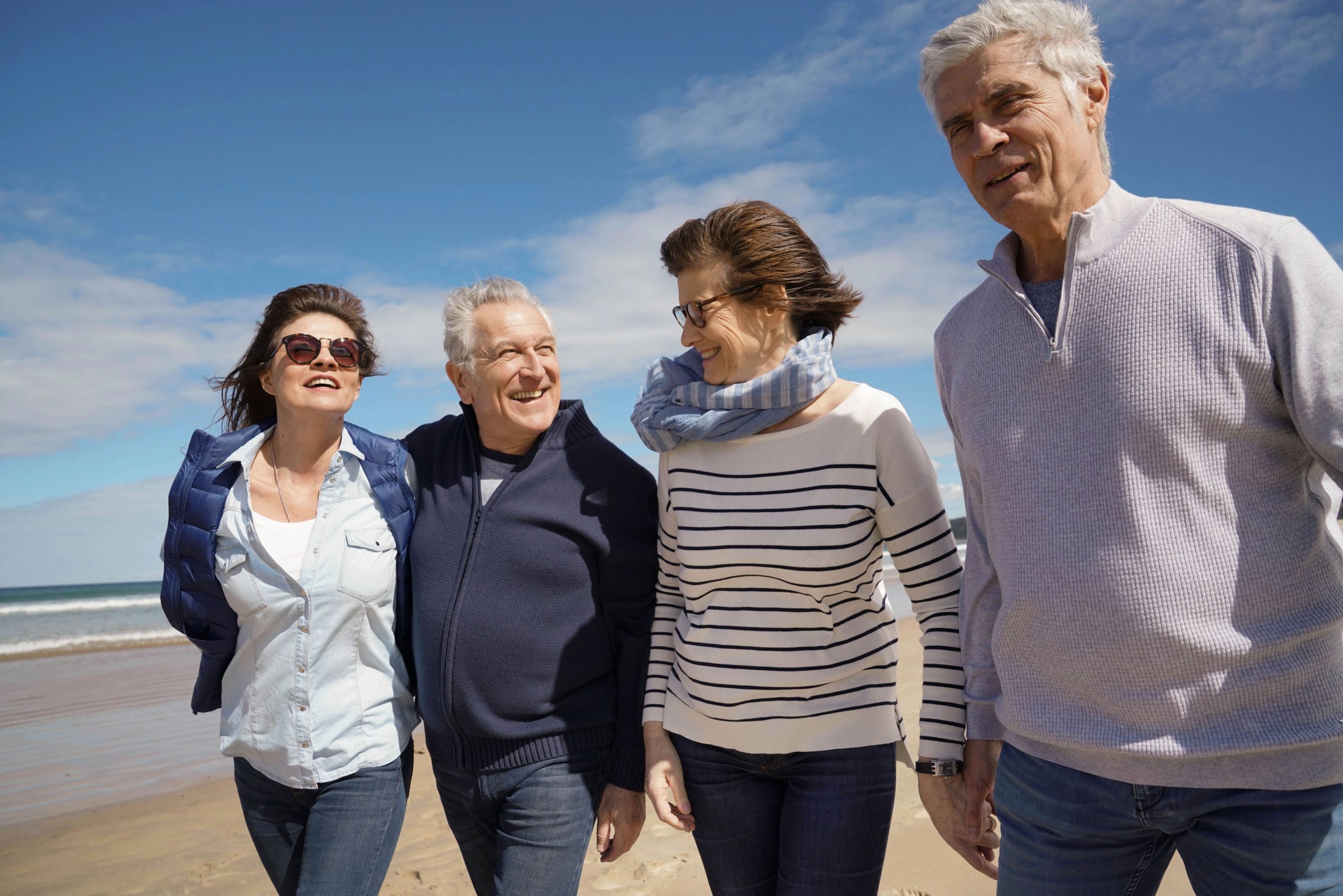 Group of senior people walking together on the beach